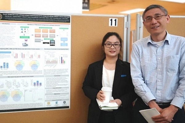 REDI-NET Partners, Hsiao-Mei and Le from the Naval Medical Research Center standing beside their poster at the One Health Research Posters Symposium.